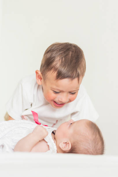 istock Little Cute Boy Playing with His Infant Sister and Smiling 924540330