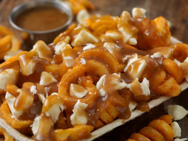Curly Fry Putin Curly Fry Poutine, with Brown Gravy and Cheese Curds in a Take out Container curly fries stock pictures, royalty-free photos & images