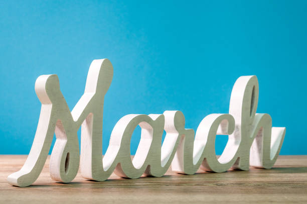 The word march carved of wood at blue background. Spring beginning concept The word march carved of wood at blue background. Spring beginning concept. march month photos stock pictures, royalty-free photos & images