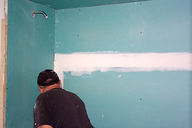 Contractor Mudding Drywall Seam stock photo
