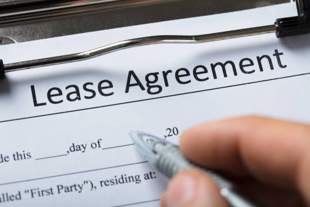 Human Hand Filling Lease Agreement Form Close-up Of A Human Hand Filling Lease Agreement Form With Pen lease agreement stock pictures, royalty-free photos & images