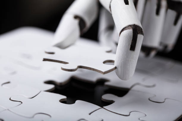 робот холдинг головоломки - jigsaw piece puzzle jigsaw puzzle metal стоковые фото и изображения