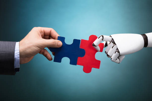 istock Businessperson And Robot Holding Jigsaw Puzzle 924555562