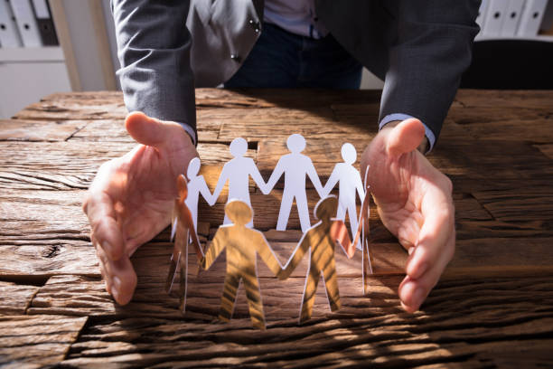 istock Businessperson Protecting Paper Cut Out Figures 924555964