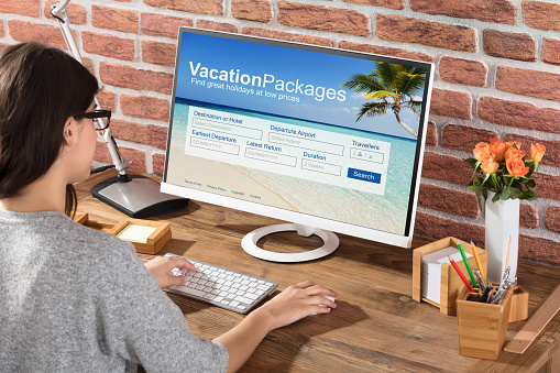 Close-up Of A Woman Filling The Online Vacations Packages Form On Computer