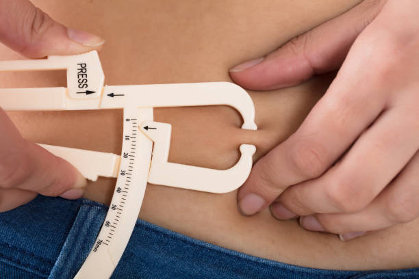 istock Woman Measuring His Body Fat With Calipers 924559754