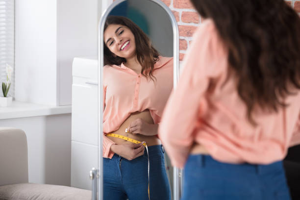 mulher feliz, cintura com uma fita de medição - torso women jeans abdomen - fotografias e filmes do acervo