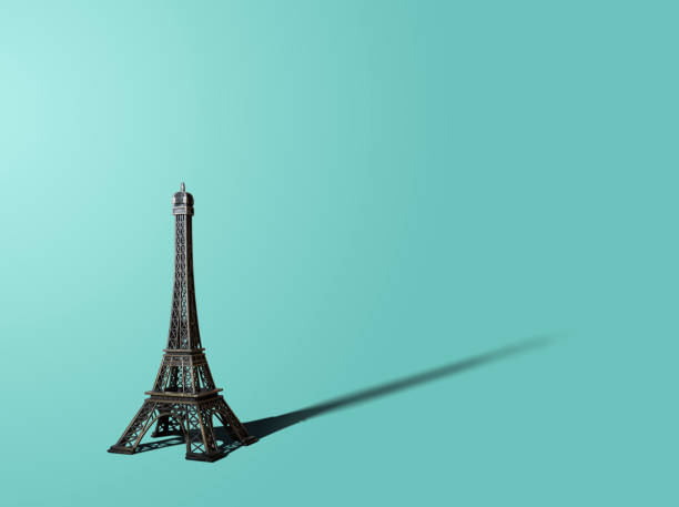 On a blue, turquoise, green pastel background is a figurine of the Eiffel Tower. A view from the front of the Eiffel Tower. Pastel background, pastel colors.