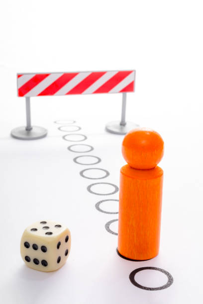 istock Playing board game with orange pawn heading to the border 924565630