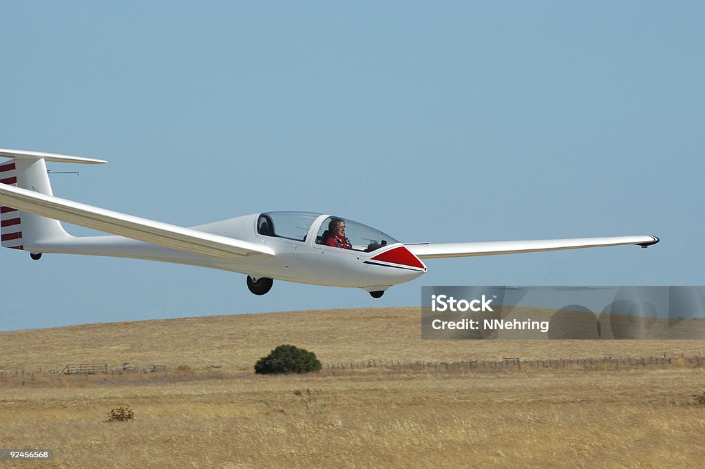 Blanc Planeur landing dans un champ herbeux sur une belle journée. - Photo de Planeur libre de droits