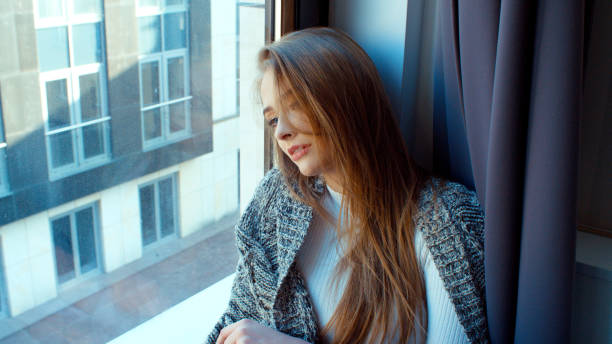 istock Young pensive woman sitting by a window. 924569110