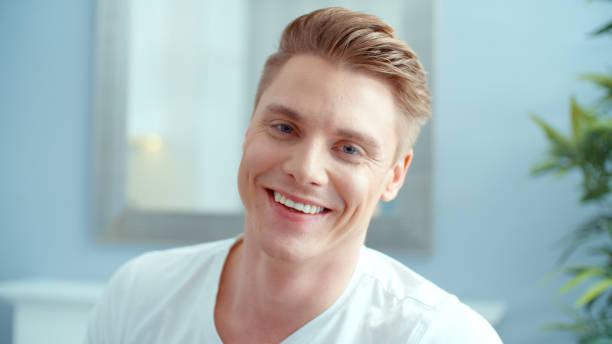 Portrait of handsome man smiling to a camera, indoors. stock photo
