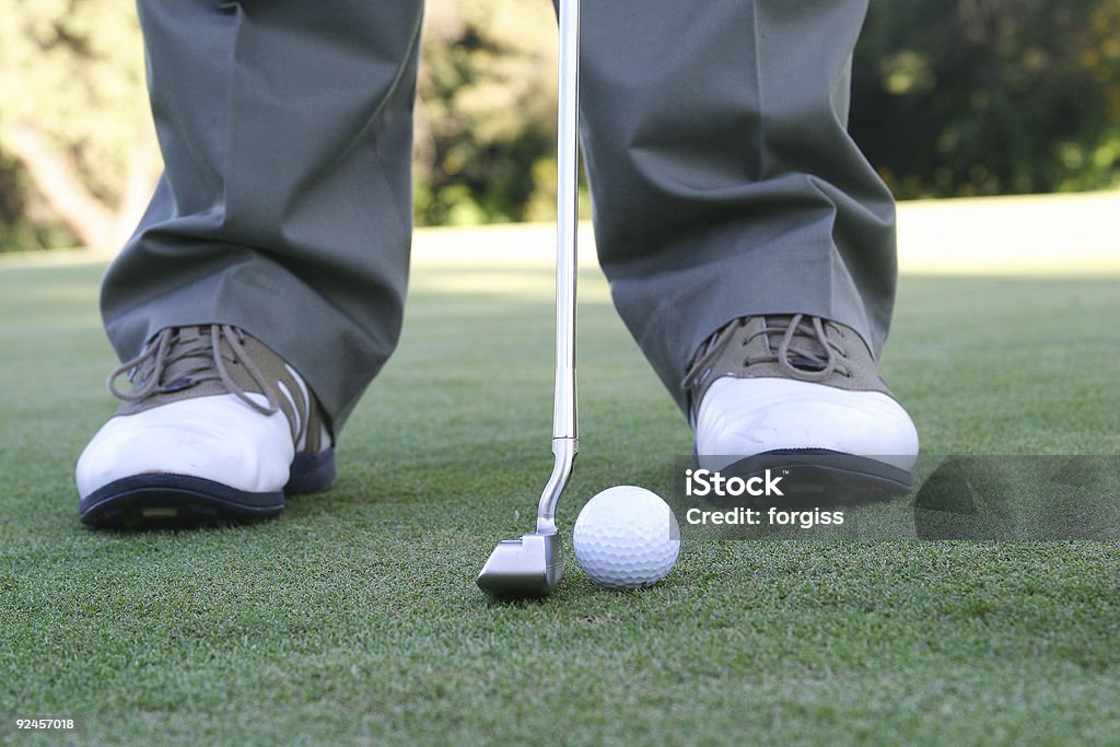 Człowiek na pole golfowe zielonej Przygotowanie aby umieścić piłkę - Zbiór zdjęć royalty-free (Golf - Sport)
