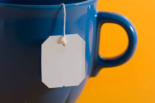 ティーバッグラベルからぶら下がっているものなら、 - cup tea teabag tea cup ストックフォトと画像