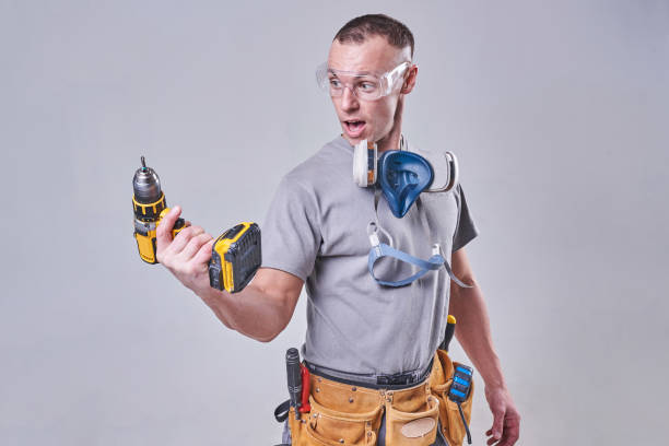 istock Master Builder-finisher in their working clothes, surprised the drill 924575412