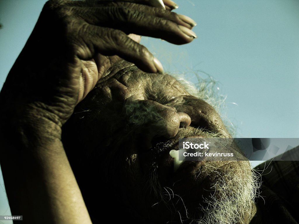 Sepia Photo of Homeless Man Smoking a homeless indian man smoking Indigenous Peoples of the Americas Stock Photo