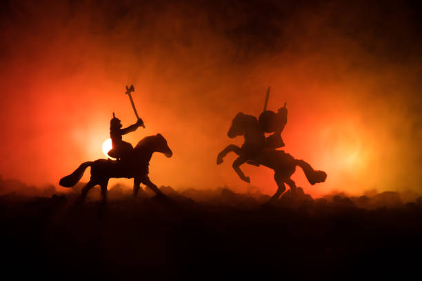 istock Medieval battle scene with cavalry and infantry. Silhouettes of figures as separate objects, fight between warriors on dark toned foggy background. Night scene. 924589664