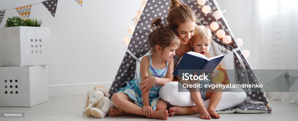 family mother reading to children book in tent at home family mother reading to children book in tent in playroom at home Child Stock Photo