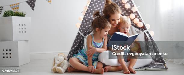 Family Mother Reading To Children Book In Tent At Home Stock Photo - Download Image Now