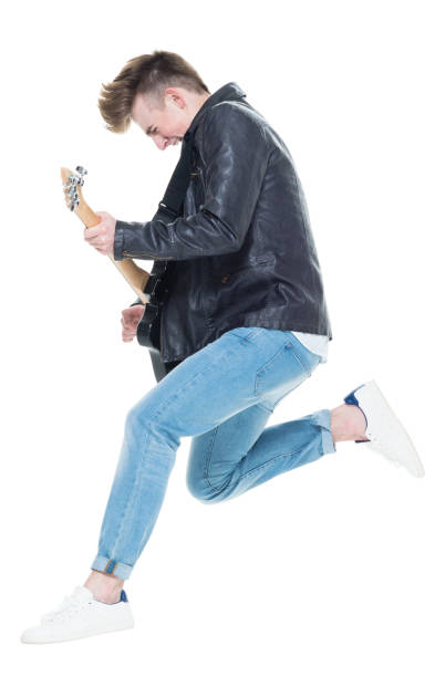 guapo varón joven tocando una guitarra eléctrica y saltando - isolated on white studio shot guitar young men fotografías e imágenes de stock