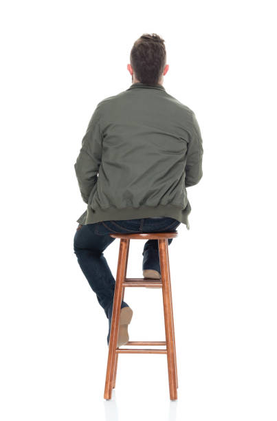 istock Attractive man with beard with coffee and phone sitting on stool 924620318