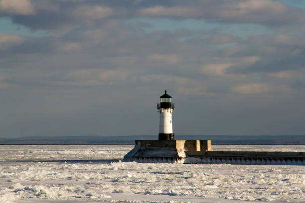 istock Frozen Lake Superior shoreline with lighthouse on shipping pier 924627406
