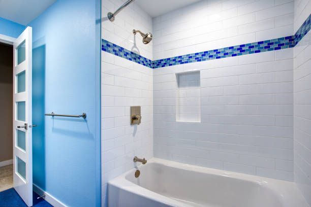 Gorgeous bathroom with blue walls Fantastic bathroom with a drop-in tub and shower combo framed by a white subway tiled backsplash fitted with a tiled niche flanked by blue mosaic border tiles. niche photos stock pictures, royalty-free photos & images