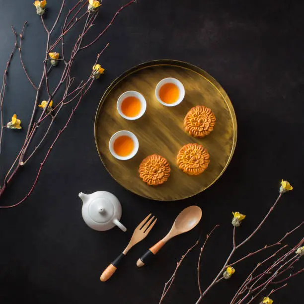 Flat lay mid autumn festival food and drink on black background.