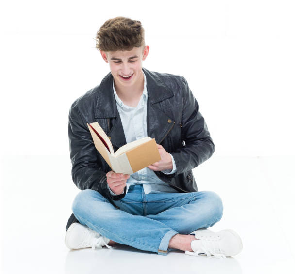 istock Attractive young man holding books and sitting on floor 924635788