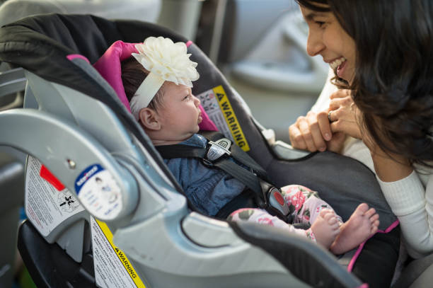 istock Mom Buckling Infant Into Car Seat 924636556