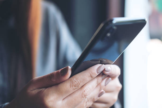 istock Closeup image of hands holding and using smart phone in modern cafe 924636830