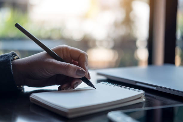 istock Closeup image of a woman's hands writing on notebook on the table 924636848