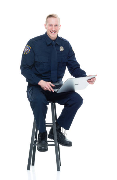 istock Handsome police officer sitting and using a laptop 924639666