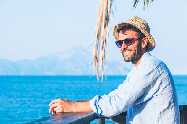 istock Young handsome man enjoying the view at the beach bar 924641112