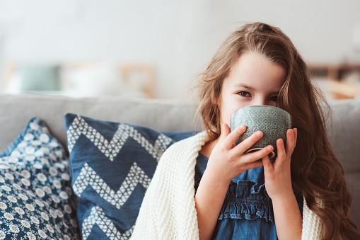 muchacha del niño beber té caliente para recuperarse de la gripe. Cura a los niños y proteger la inmunidad del virus estacional, concepto de salud photo