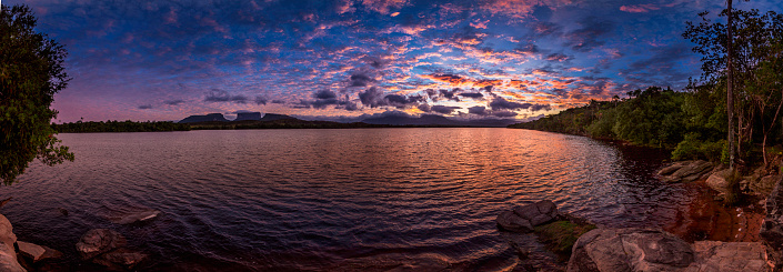 Early  morning panoramic view of the Carrao river in the Canaima National Park, Venezuela. Group of tepuis, from left to right: Kurun, Kusary, Kurawaik and Tok Pochik. Canaima is a world known place for the beauty of nature and countless waterfalls. Canaima is visited for tourist all around the world during all year round. During rainy season navigation on the Churun river is possible to visit the Angel falls, the tallest waterfall in the world with 976 mt of water free fall.