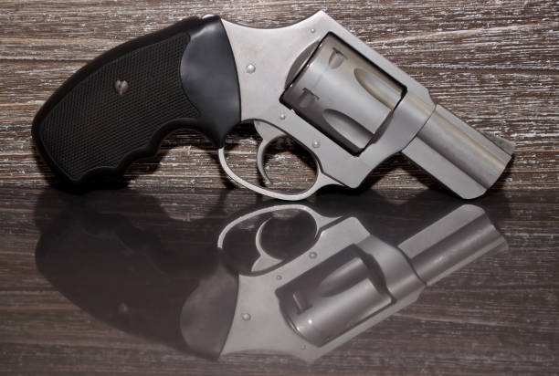 istock A stainless revolver on a wooden background 924649598