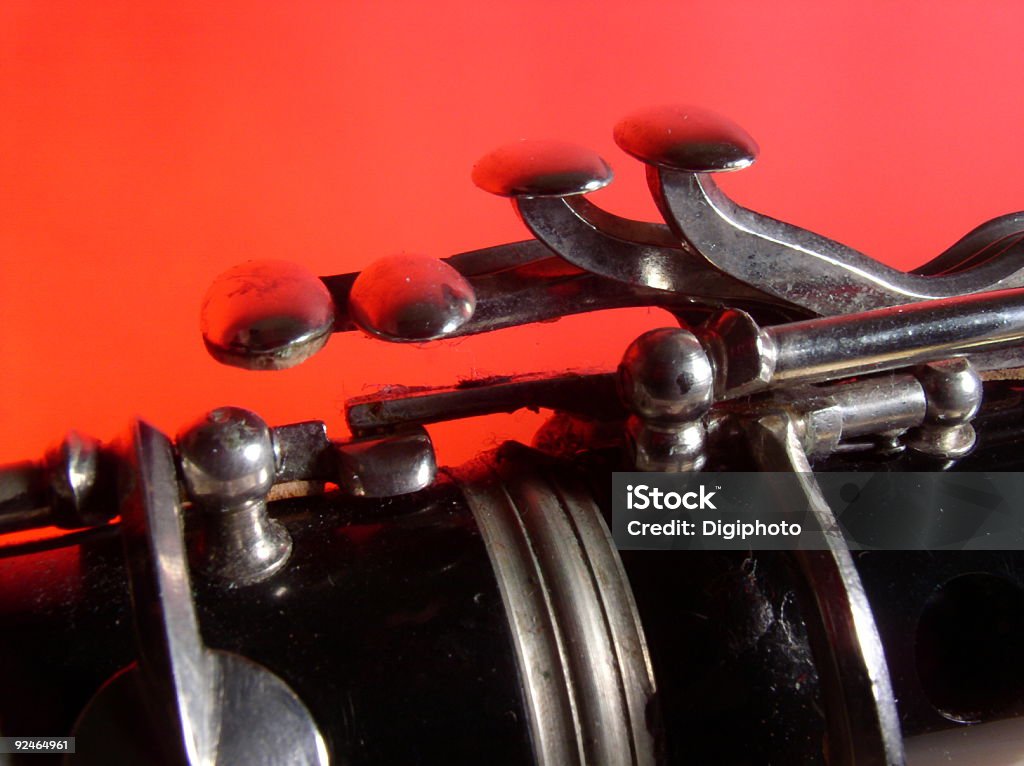 Clarinet on Red Clarinet seems to sink and blend into a flat red background. It shows silver keys, and joint. Use for any music, band, orchestra, talent, school, etc. Abstract Stock Photo