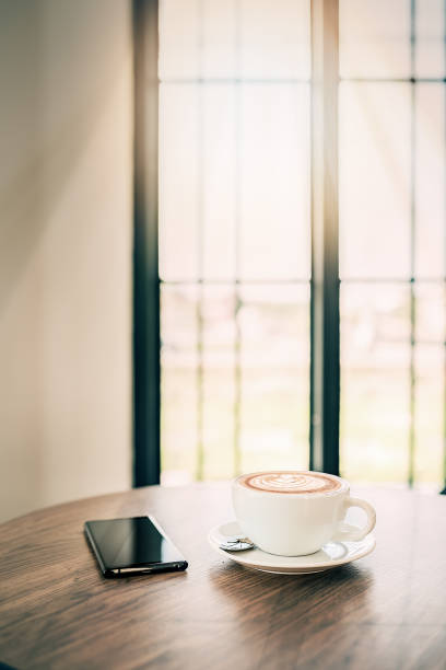 istock White cup of coffee and smartphone on wooden table 924660460