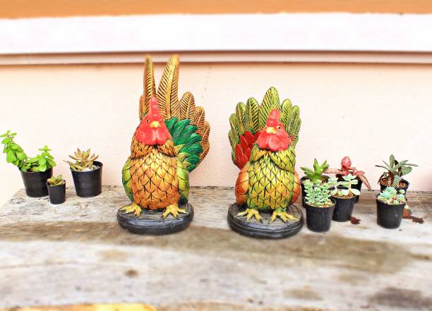 Two chicken dolls on a wooden board with a small cactus tree.