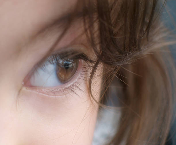 close up view of eye looking through hair
