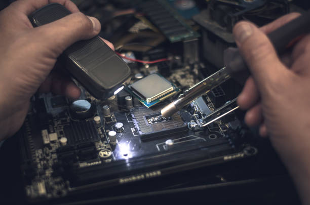 istock Computer repair man installing a CPU on mother board. Repair of central processor unit. 924667042
