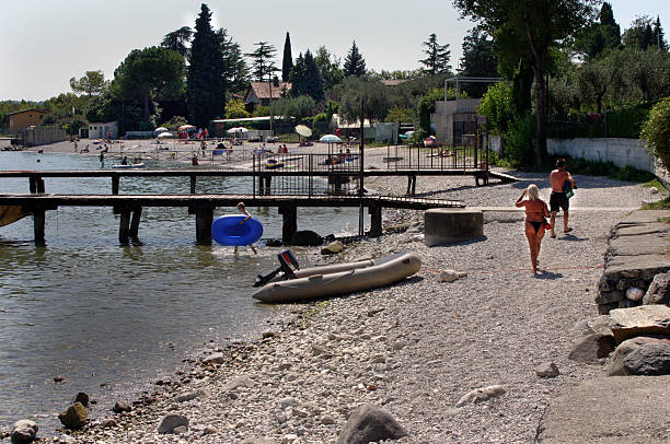 Lake Garda Beach 2 Couple walking on beach looking for a place to sit backside for a girl on the beach stock pictures, royalty-free photos & images