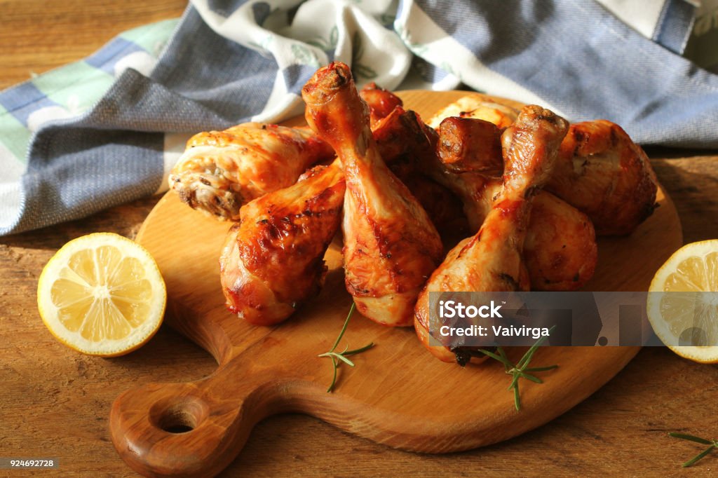 Grilled chicken legs on cutting board.Rustic dinner background Grilled chicken legs on cutting board.Rustic dinner background . Chicken Drumstick Stock Photo