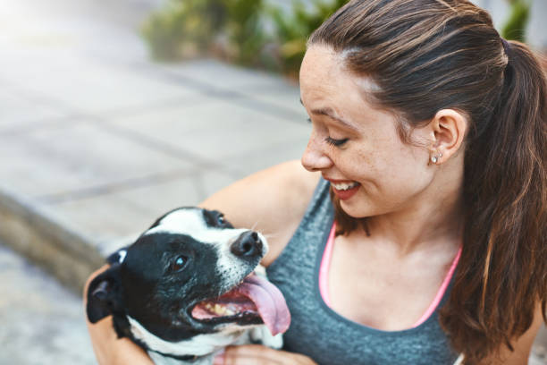 istock Pretty girl happily playing with her pet dog 924698658
