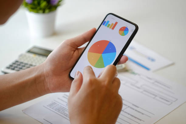 istock Businessman's hands shows mobile smartphone with analysis data on screen at desk. 924698682
