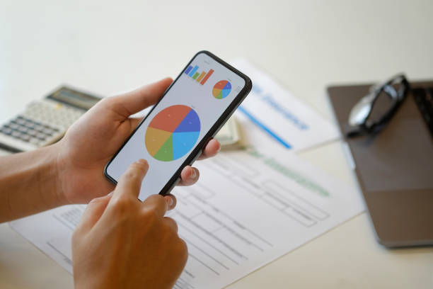istock Businessman's hands shows mobile smartphone with analysis data on screen at desk. 924698720