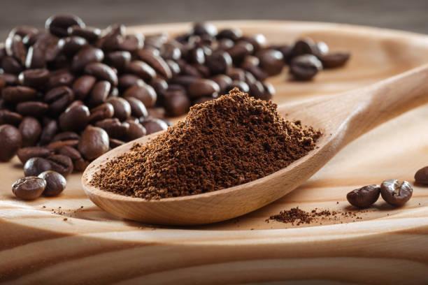 Ground coffee in spoon. Coffee beans. Ground coffee in wooden spoon. Coffee fried grain on wooden platter. Close-up. Coffee ground, coffee beans. ground coffee stock pictures, royalty-free photos & images