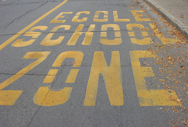 school zone ecole school zone painted on a montreal street ecole stock pictures, royalty-free photos & images