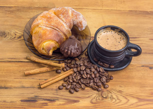 istock Coffee in black ceramic cup, croissant and chocolate truffle 924708974